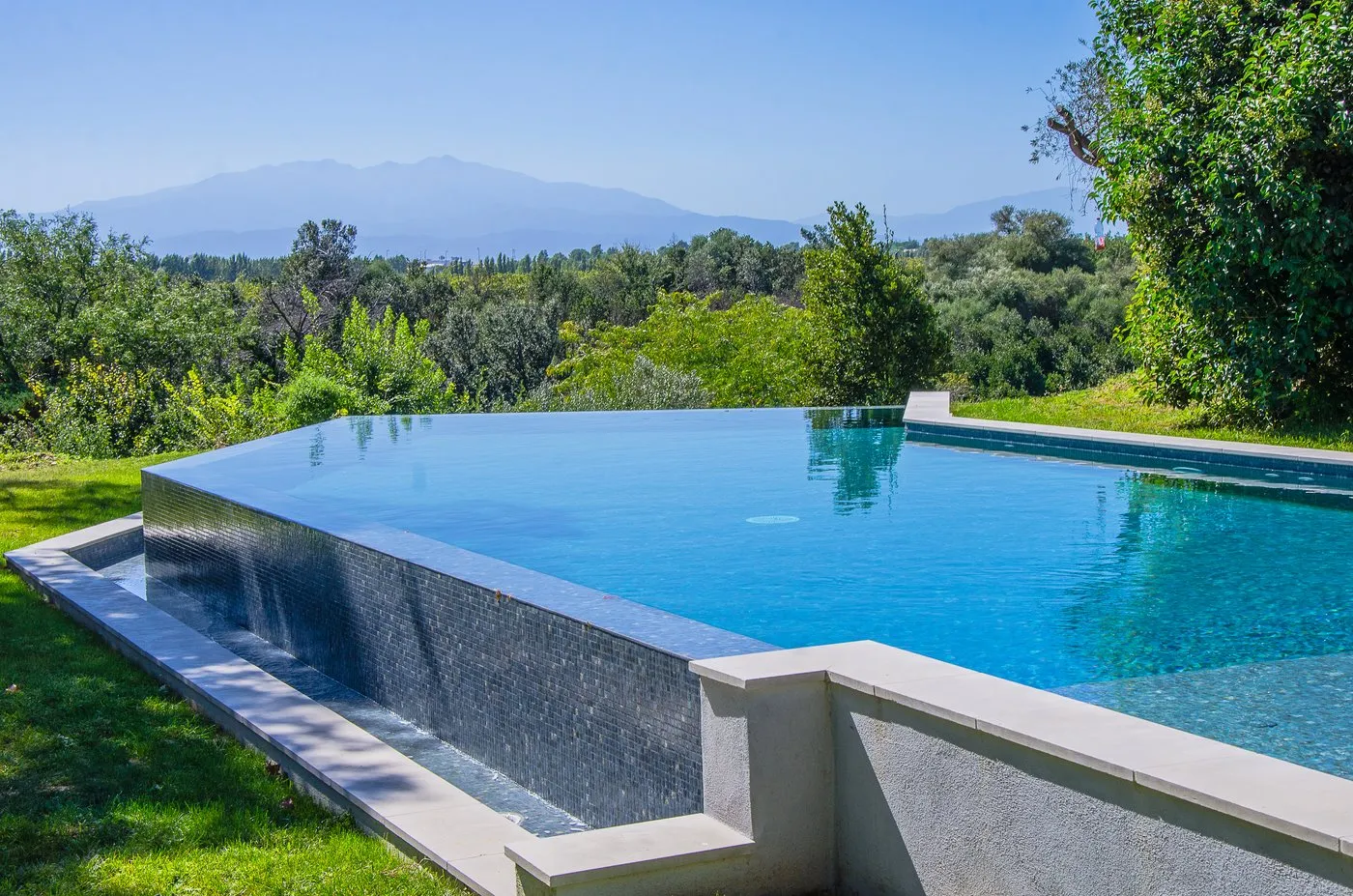 Piscine à débordement avec vue panoramique sur les montagnes — réalisation Beaulieu Piscines